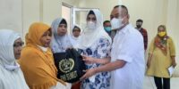 Ketua PWI Sumut H Farianda Putra Sinik SE dan Ketua IKWI Sumut Hj Fadia Achri Yulan menyerahkan bantuan paket Idul Fitri kepada para warakawuri di Medan, Rabu (20/4). (foto: pwisumut)
